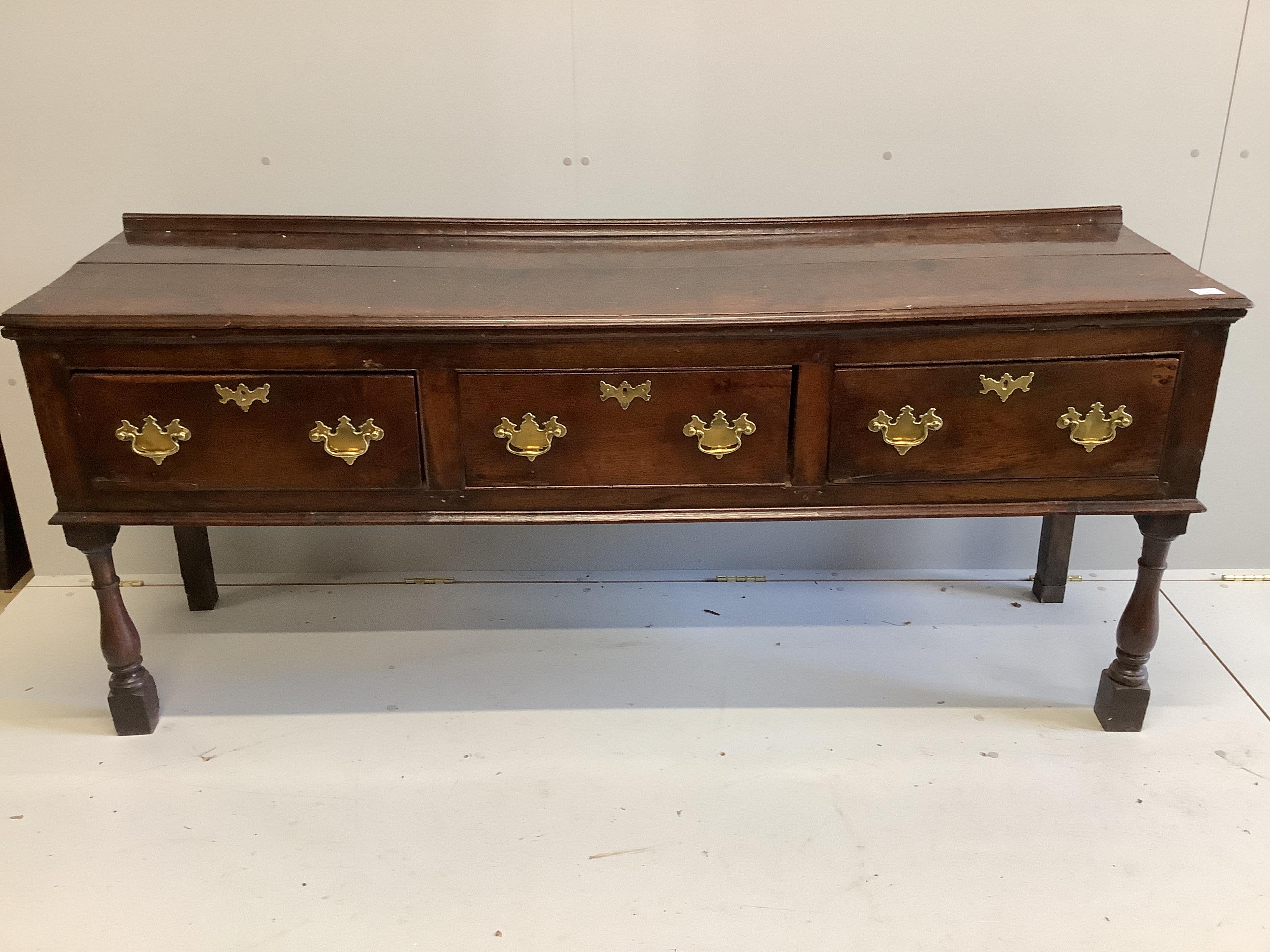 An 18th century oak low dresser, fitted with three drawers, raised on turned legs, length 184cm, depth 48cm, height 80cm